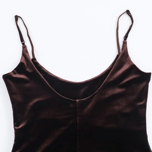 Detailed macro view of deep brown velvet fabric texture and slim shoulder straps