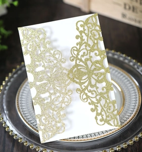 Detail of dark green laser cut wedding invitation with glitter finish on elegant plate