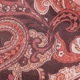 Macro shot of bohemian paisley printed chiffon fabric in reddish-brown and orange tones