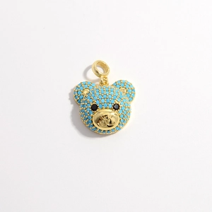 Detail of bear pendant with turquoise blue stones and a gold ring fastener