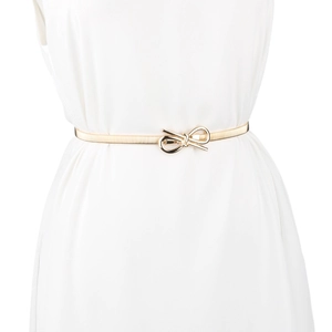 Detail of gold elastic metal belt with elegant bow buckle on a white dress