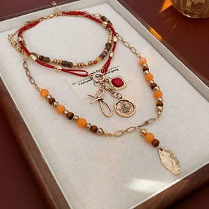 Detail of vintage beaded bow necklace with red pendant and multi-layered strings