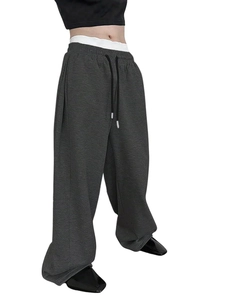 Detail of dark grey drawstring waist on loose-fit joggers with soft cotton texture
