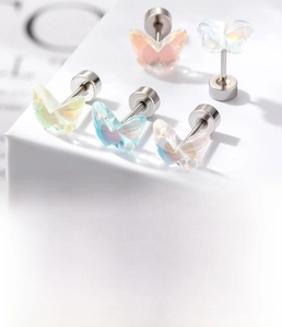 Détail macro de boucles d'oreilles papillon en résine et acier titane à fond plat