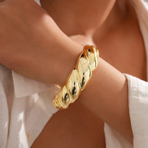 Detailed macro view of the twisted rope texture and polished gold finish on the bracelet