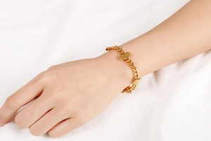 Detailed close-up of a golden pineapple charm on a classic Cuban link bracelet for women