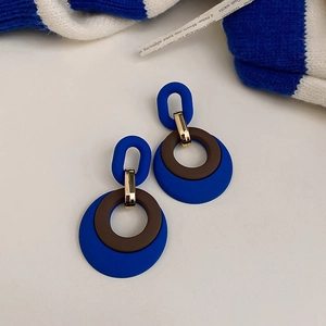 Detail of blue and brown acrylic geometric circle earrings with gold metal connectors