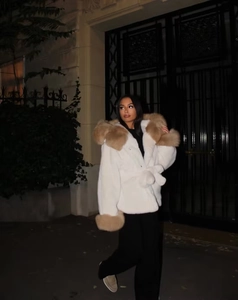 Détail macro d'une veste en fausse fourrure blanche avec col beige et ceinture à la taille