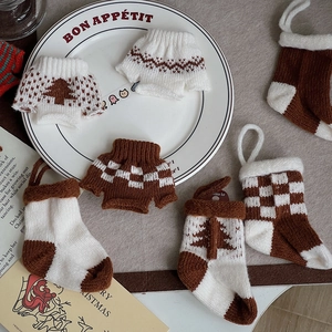 Close-up of knitted mini sweaters and Christmas stockings with rustic holiday patterns