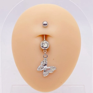 Macro detail of a silver butterfly navel ring with inlaid rhinestones on a skin model
