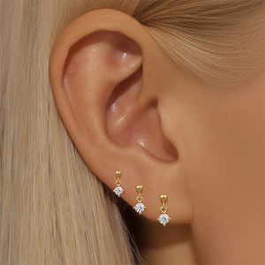 Detail showing three marquise zircon stud earrings in gold finish worn on the ear