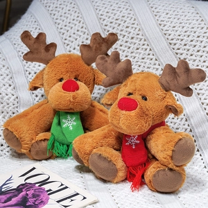 Cute Christmas reindeer plush toys with red and green knit scarves on white blanket