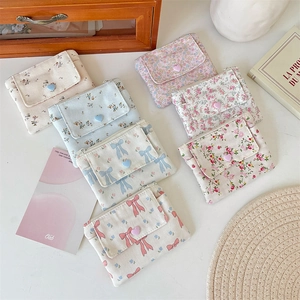 Détail de porte-monnaie en toile florale avec boutons cœur et fermeture éclair