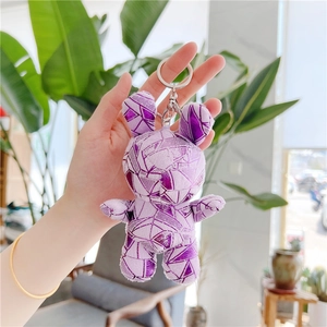 Detail of purple geometric plush rabbit keychain with silver metal lobster clasp and ring