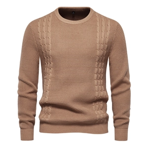 Detailed view of khaki waffle knit and cable texture on men's crewneck sweater
