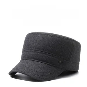 Detail of dark grey winter flat cap featuring thick woolen fabric and metal side logo
