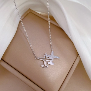 Macro shot of silver titanium airplane pendants on a silk background and jewelry box