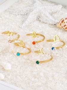 Macro detail of adjustable gold plated zodiac rings with sparkling colorful zircons