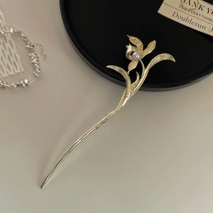 Close-up of golden orchid hair pin with white pearl accent in Neo-Chinese style