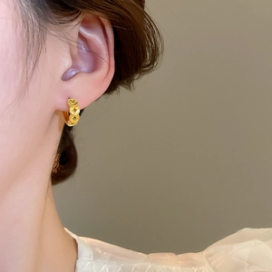 Close-up of elegant 18k gold plated coin pattern hoop earrings worn by a model