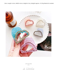 Detail of heart-shaped acetate hair claw clips with rhinestones in candy colors