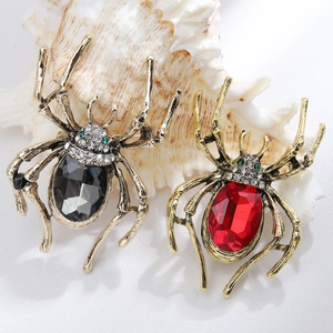 Detailed view of red and black spider brooches with crystals on a white shell