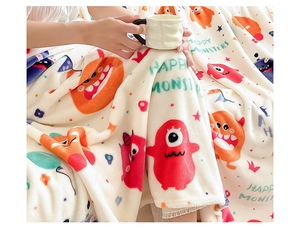 Cozy flannel blanket with colorful monster print and Happy Monsters text in a home setting