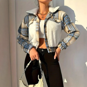 Detail of blue-brown plaid tweed jacket with white faux fur collar and button texture