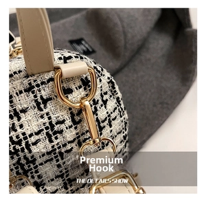 Detailed close-up of premium gold metal hooks on a stylish tweed plaid backpack