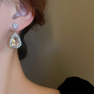 Macro view of teardrop crystal drop earrings with sparkling pavé-set rhinestones
