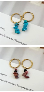 Detail of bohemian gold hoop earrings with turquoise and purple stone pendants