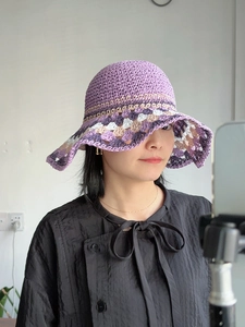 Close-up of purple crochet sun hat with colorful hollow patchwork wide brim for beach