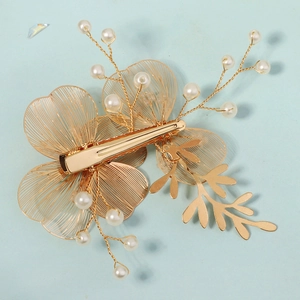 Handmade golden floral bridal hair clip with hollow petals and elegant white pearls