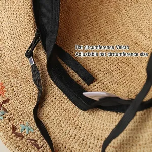 Handmade raffia sun hat with adjustable velcro strap and black windproof lanyard detail