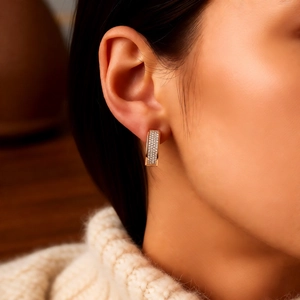 Gros plan de boucles d'oreilles U en or rose 18k avec zircon blanc sur un mannequin femme