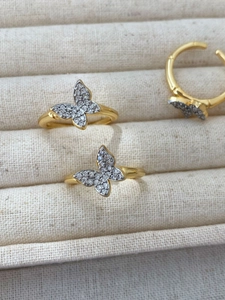 Macro detail of copper butterfly ring featuring shimmering micro-pave crystals on tray