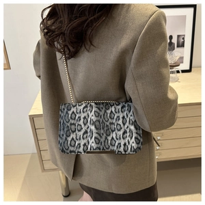 Close-up of leopard print chain bag with gold metal trim and textured fabric finish