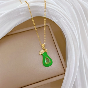 Elegant gold titanium necklace featuring green teardrop pendant and crystal leaf accents