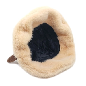 Dettaglio della fodera trapuntata nera calda e della pelliccia sintetica del cappello beige