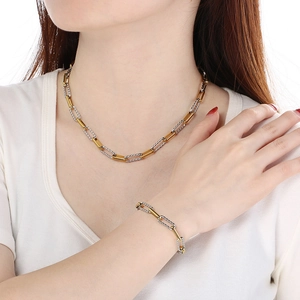 Macro shot of two-tone gold and silver link chain necklace and bracelet on model