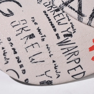 Close-up of high-quality woven fabric stitching and black-red street graffiti on the cap