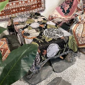 Detail of bohemian floral woven blanket with white tassels used as a rustic tablecloth