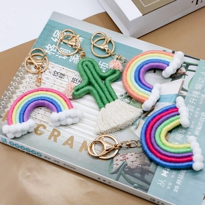 Handmade woven cotton rainbow and cactus keychains on magazine background
