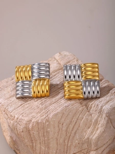 Detail of two-tone gold and silver geometric square earrings with woven texture on stone