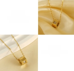 Detail of 18k gold plated titanium necklace with cube pendant and square zircon stone