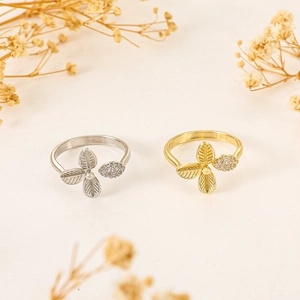 Detailed view of leaf rings in gold and silver finish with sparkling zircon stones