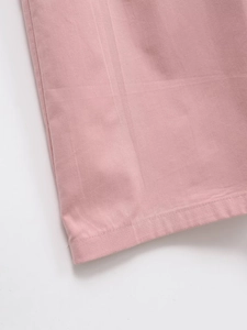 Détail de l'ourlet d'une robe rose montrant une couture à double aiguille