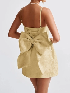 Rear view detail of beige jacquard mini dress with spaghetti straps and a large back bow
