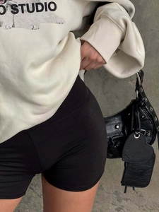 Look urbain : sweat en coton crème assorti d'un short de cycliste noir et sac rétro