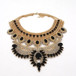 Close-up of bohemian multilayer gold necklace with black gemstones and crystal accents